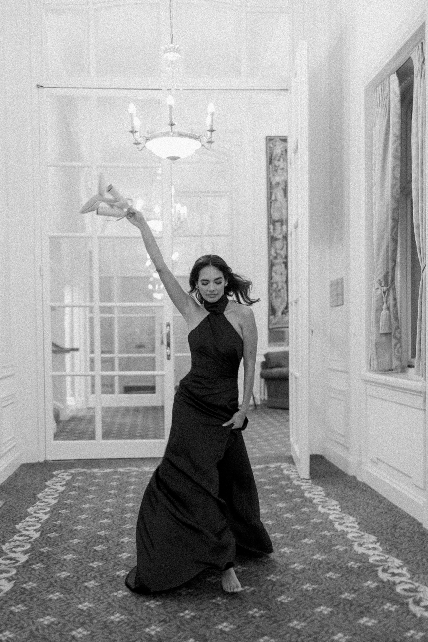 bride in evening dress running down corridor at Luton Hoo Hotel