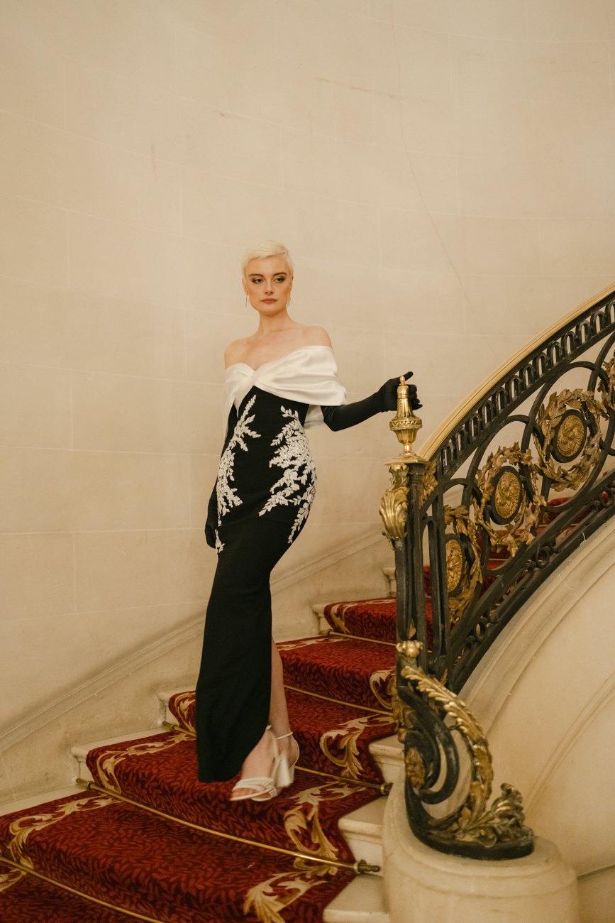 woman on luxury hotel staircase in evening gown